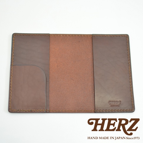 深棕色皮革護照套，內有兩個隔層，左側隔層為開放式插槽，右側隔層為平整皮革面，邊緣有縫線裝飾，右下角有燙金品牌標誌。