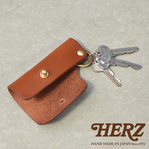 棕色皮革鑰匙套，附黃銅色金屬扣環及兩顆黃銅色按扣，可收納鑰匙。