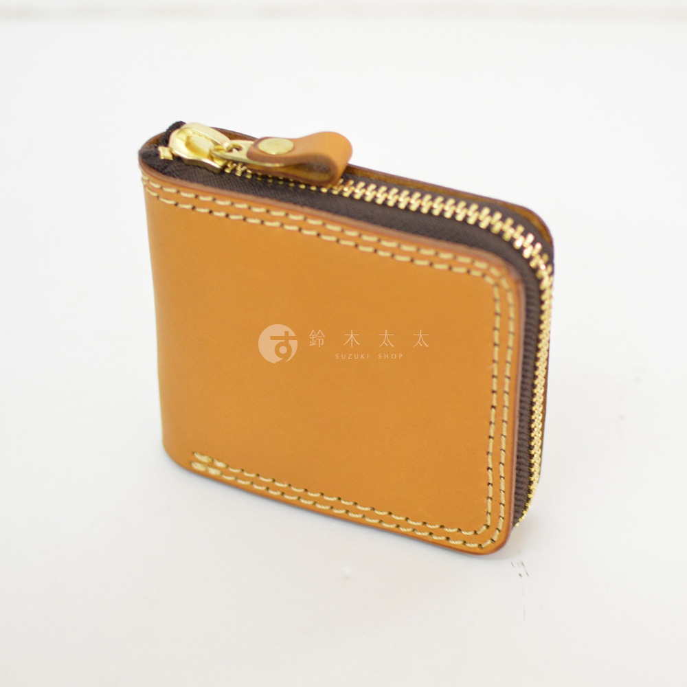 一個棕色職人手作皮革短夾，採用全包式拉鍊設計，皮革質感溫潤，邊緣縫線工整，並印有鈴木太太 SUZUKI SHOP 的品牌商標。