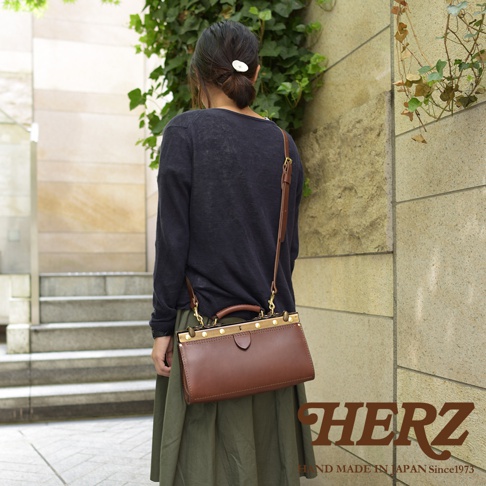 職人手作復古皮革口金兩用手提包，咖啡色皮革，搭配金色金屬扣環及提把，可肩背或手提。