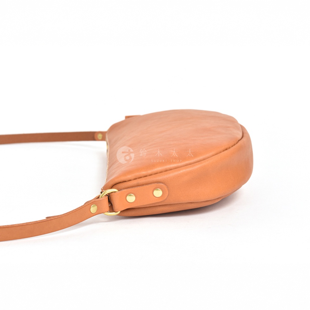 日本HERZ職人手作皮革半圓馬鞍包，採用褐色皮革材質，從側面拍攝，展示包包的金屬扣環細節