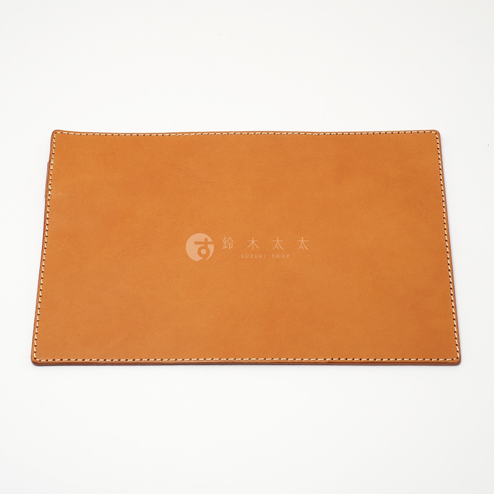 職人手作皮革B6記事本書套，以棕褐色皮革製成，邊緣以白色縫線包邊，中央印有品牌標誌。