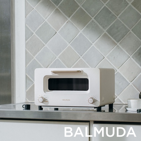 The Toaster Pro 蒸氣烤麵包機專業版 K11C-SE，白色機身，配有金色提把和旋鈕，置於廚房檯面上。