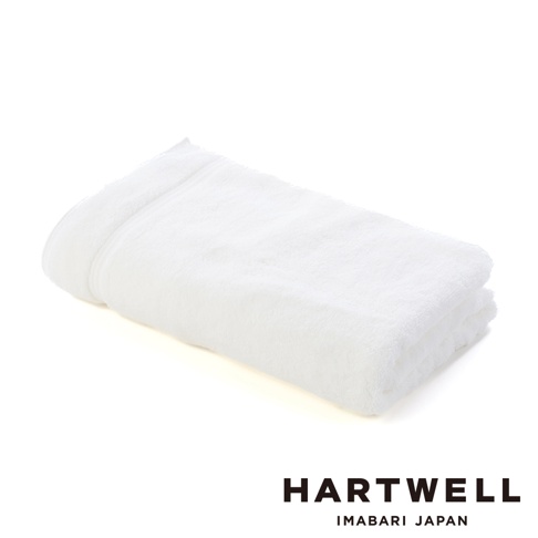 一條折疊的白色毛巾，觸感柔軟，質地蓬鬆，邊緣有細緻的滾邊，整體呈現簡潔優雅的風格。