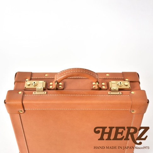 職人手作皮革英倫風便攜手提行李箱，淺棕色皮革，帶有兩個金色鎖扣、皮革提把和撞色車縫線。