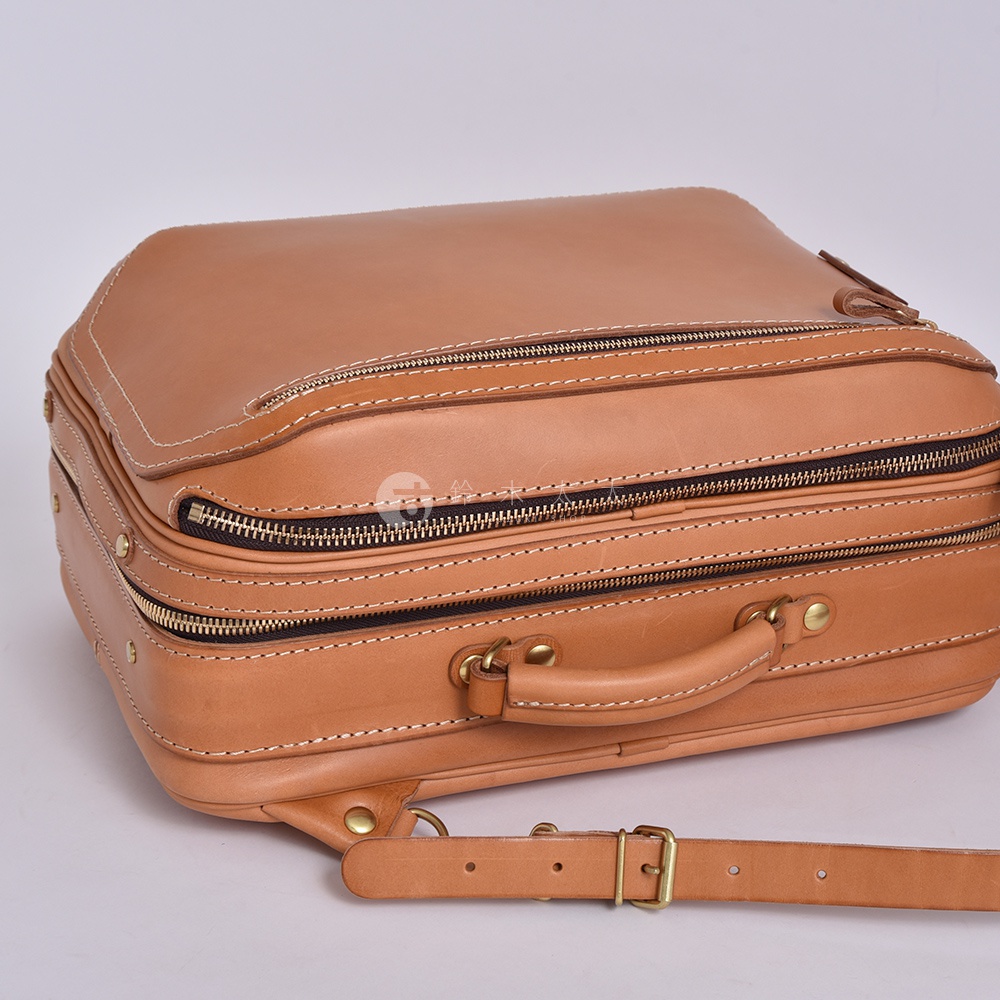職人手作皮革兩用商務後背包 R-33，採用淺棕色皮革，設有兩層主要拉鍊隔層，搭配黃銅色五金配件，包括一個提把和可調節的肩帶。