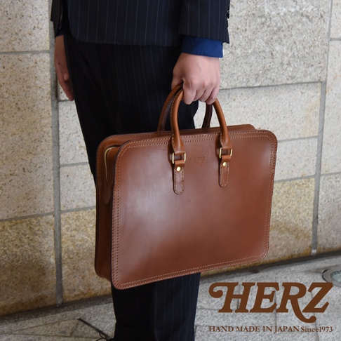 職人手作皮革手提商務公事包，棕色皮革，簡潔方形設計，配有提把及拉鍊開合，適合商務場合。