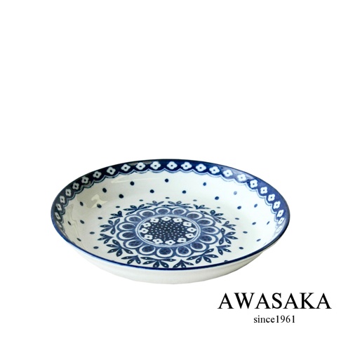 白色陶瓷料理盤，邊緣飾有藍色小圓點與連續的菱形圖案，盤面中央有藍色對稱花卉圖騰，整體風格為歐式。