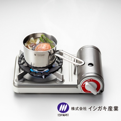 不鏽鋼瓦斯爐架，爐架上放置著一個不鏽鋼湯鍋，鍋內有鮭魚、馬鈴薯及蘆筍等食材，下方有藍色火焰。瓦斯爐主體為銀灰色，右側有紅色旋鈕。