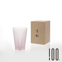 粉色漸層的玻璃杯，杯身呈細長錐形，底部有三瓣花狀設計。一旁擺放著木質包裝盒，盒面印有黑色日文書法字體。