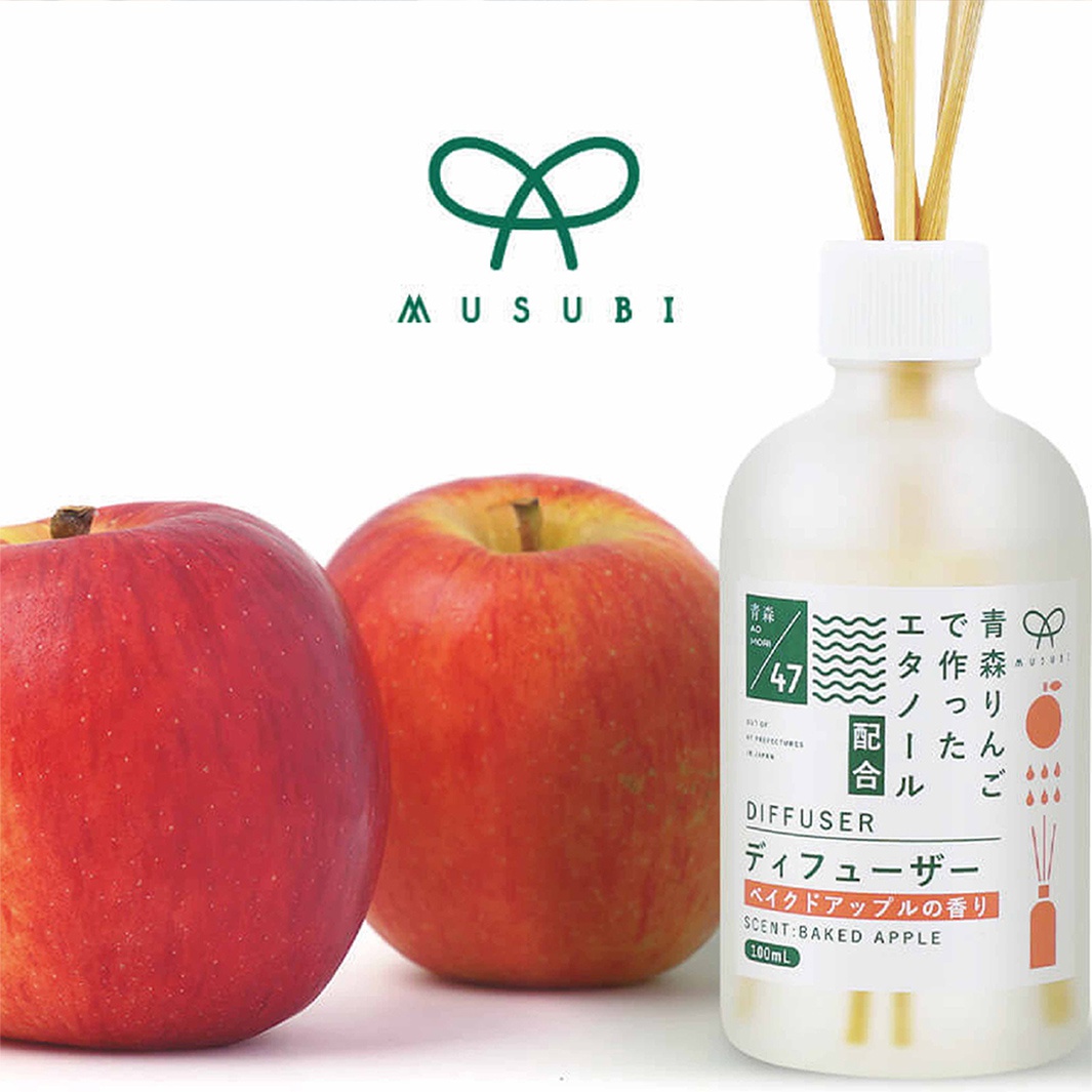 模式B： 兩個紅色的蘋果和一個裝有擴香枝的擴香瓶，瓶身貼有標籤，上面寫有日文文字和「SCENT:BAKED APPLE 100ML」。