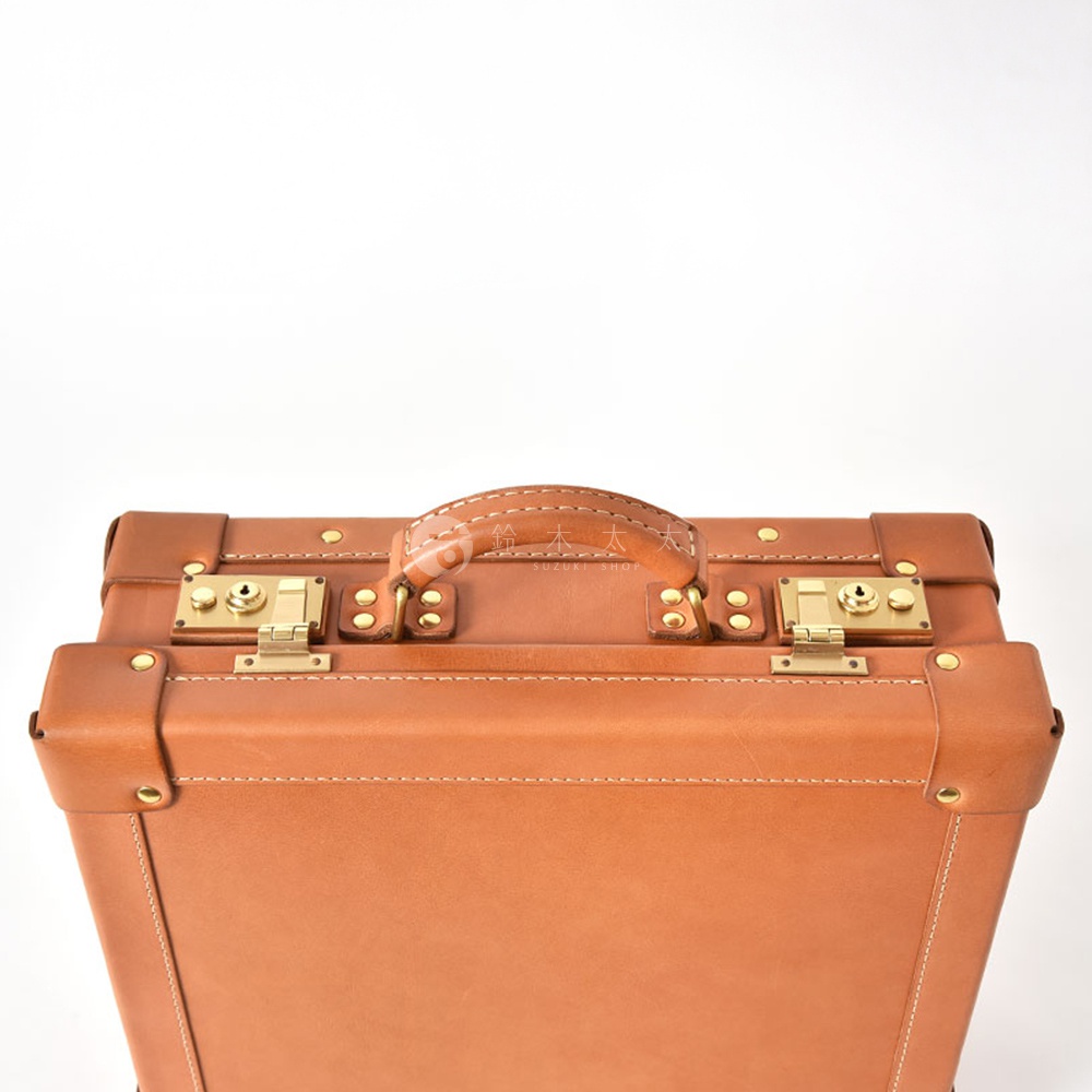 棕色皮革英倫風手提行李箱，配有金色鎖扣、鉚釘裝飾及皮革提把。