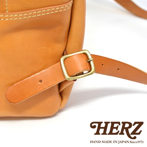 職人手作皮革休閒風後背包 R-93，採用天然皮革材質，呈現溫潤的棕褐色，搭配古銅色金屬扣環，展現質感細節。