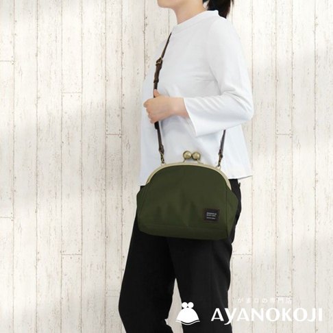 一款軍綠色大玉口金斜背包，包上有小小的皮革標籤，包包上有品牌 AYANOKOJI 的字樣。