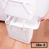 白色塑膠夾縫疊疊洗衣籃專用蓋，平整的表面，邊緣設有淺淺的凹槽，可放置在堆疊的洗衣籃之間，由手部操作放置。