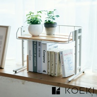 白色金屬框架搭配木質層板的雙層收納架，上方擺放兩盆綠色植物，下方層架則收納多本不同尺寸的書籍，整體呈現簡約自然的風格。