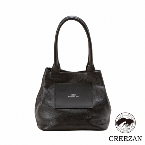 JETTER 方形托特包 CJTE-026，深棕色荔枝紋皮革材質，配有皮革提把，包身正面有一個方形黑色皮革名牌，上面印有品牌標誌和「HANDMADE IN JAPAN」字樣。