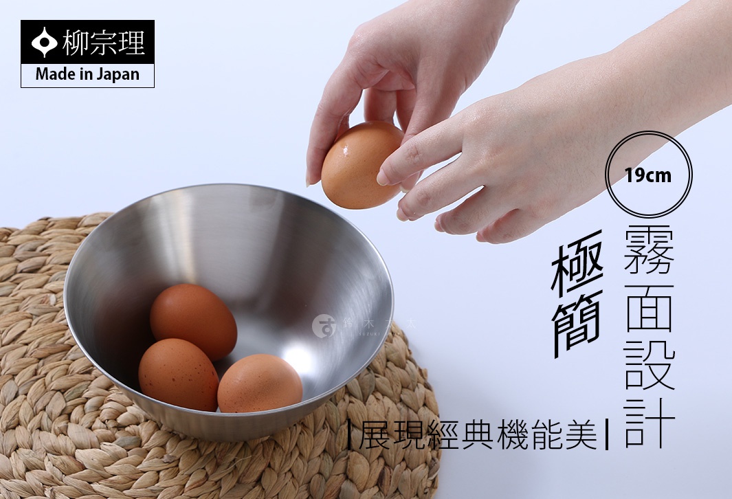 柳宗理品牌的不鏽鋼霧面調理盆，尺寸為19公分，圖片中一雙手正拿著一顆雞蛋準備放入盆中，盆內已有三顆雞蛋，調理盆置於編織草編墊上，整體呈現簡約的廚房質感。