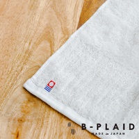 白色 RIB 今治長毛柔暖速乾直紋浴巾，織有細緻的直紋紋理，觸感柔軟，角落處帶有品牌紅色標誌，整體呈現簡約質感。