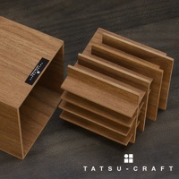 木紋筆筒，由多個分隔的淺棕色木質隔層組成，排列整齊，可容納多支筆。左側為一個開口向上的木質收納盒，表面有黑色品牌標籤。