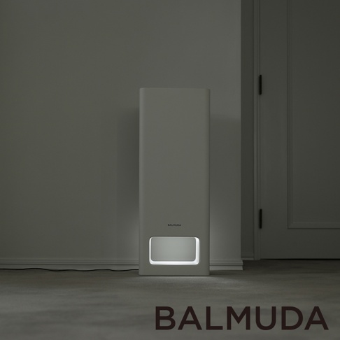 The Pure 空氣清淨機，白色長方形機身，底部有嵌入式矩形進氣口，散發柔和白光。機身正面印有 BALMUDA 品牌標誌。