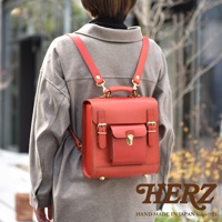 職人手作經典學院風迷你後背包，採用紅色皮革製成，配有金色金屬扣環和旋轉鎖，肩帶亦為紅色皮革。