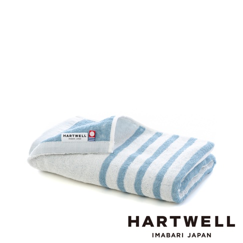一條藍白條紋的今治迷你浴巾，材質為棉，帶有「HARTWELL IMABARI JAPAN」的品牌標籤。