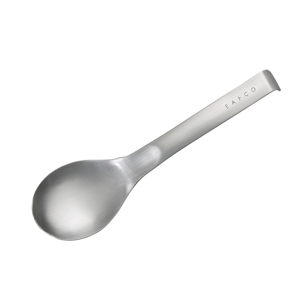 日製服務餐匙，銀色不鏽鋼材質，勺頭呈鵝蛋形，手柄末端有「EAT CO」字樣壓印。