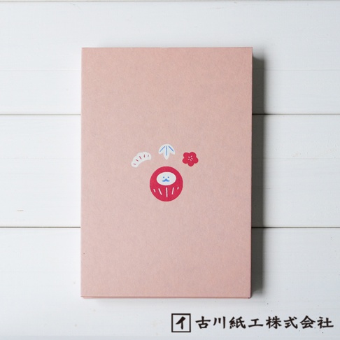 粉紅色和紙御朱印帳，封面印有紅色達摩吉祥物圖案，周圍飾有白色扇形紋飾、藍色箭頭及紅色梅花圖案。