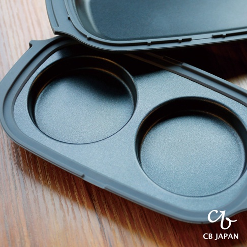 copan系列 CB JAPAN 微波爐專用燒烤盤，帶有兩個圓形烤盤，表面呈深灰色，放置於木質桌面。