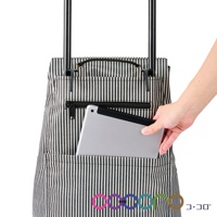 黑色與白色細直條紋帆布材質購物車，配有拉鍊前袋，其中可見一個銀色平板電腦，另一手正將其放入。