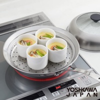 不鏽鋼蒸鍋盤，盤中盛有四個裝有茶碗蒸的白色陶瓷杯，蒸鍋盤上有圓形透氣孔，盤旁放置一個透明玻璃蓋的銀色不鏽鋼鍋蓋，整體放在電磁爐上。