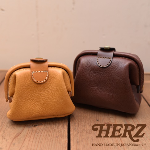 黃色與深棕色皮革口金化妝包，皆為職人手作，帶有縫線細節與金屬釦。