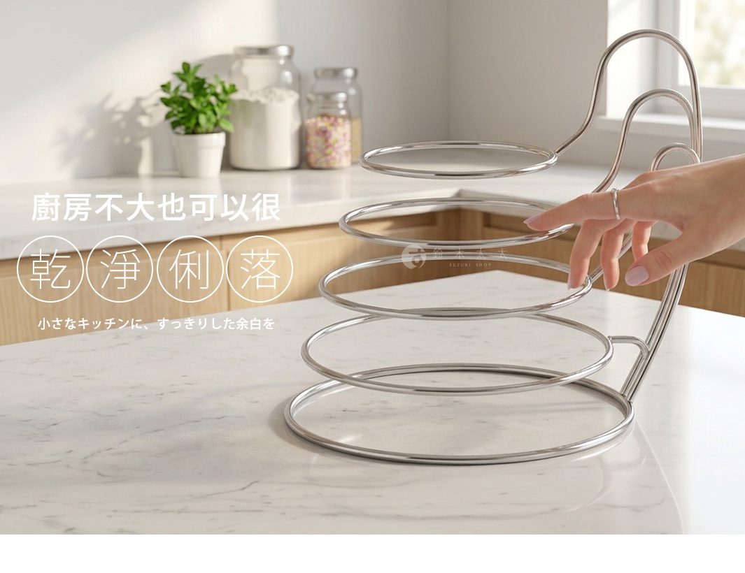 一張展示於白色大理石檯面上的銀色不鏽鋼螺旋狀收納架，架子具有多個由大到小的圓形層架，一隻手正在輕觸其中一層。背景為溫馨簡約的廚房檯面，桌上放置著玻璃收納罐與盆栽，整體影像風格明亮，圖片中附有廚房乾淨俐落的相關日文與中文字樣。