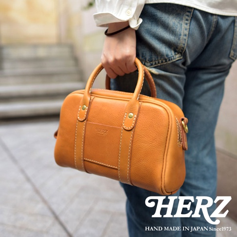 HERZ 職人手作皮革兩用迷你波士頓包，以焦糖色牛皮製作，可手提或肩背。