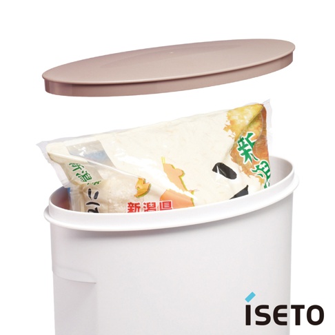 白色塑膠儲米桶，附有淺褐色橢圓形桶蓋，桶內裝有一包透明塑膠包裝的米，包裝上有日文標示，儲米桶上有「ISETŌ」品牌標誌。