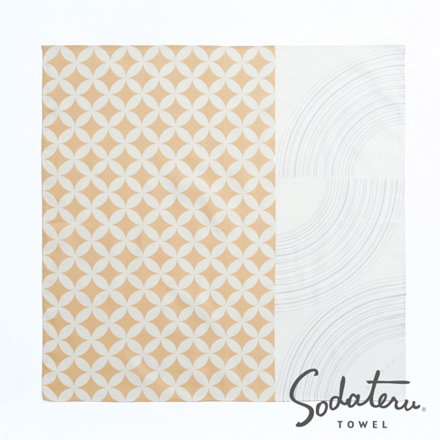 一片印有橘色幾何圖案與白色弧線圖案的浴巾，下方有 Sodateru TOWEL 的品牌標誌