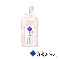 粉色長方形拭巾，印有白色雛菊圖案，材質為棉，包裝為透明塑膠袋，以麻繩捆綁。