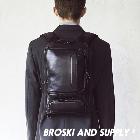 黑色防水真皮革兩用手提後背包，具有光滑的表面、多個拉鍊隔層和一個前置口袋。