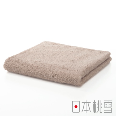 一條淺棕色精梳棉飯店毛巾，材質柔軟，織紋細緻，對折於白色背景上。