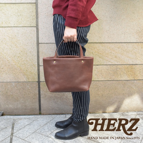 職人手作皮革4口袋極簡托特包 T-3，棕色牛革，簡約設計，頂部有提把，兩側有金屬鈕扣，適合日常攜帶。