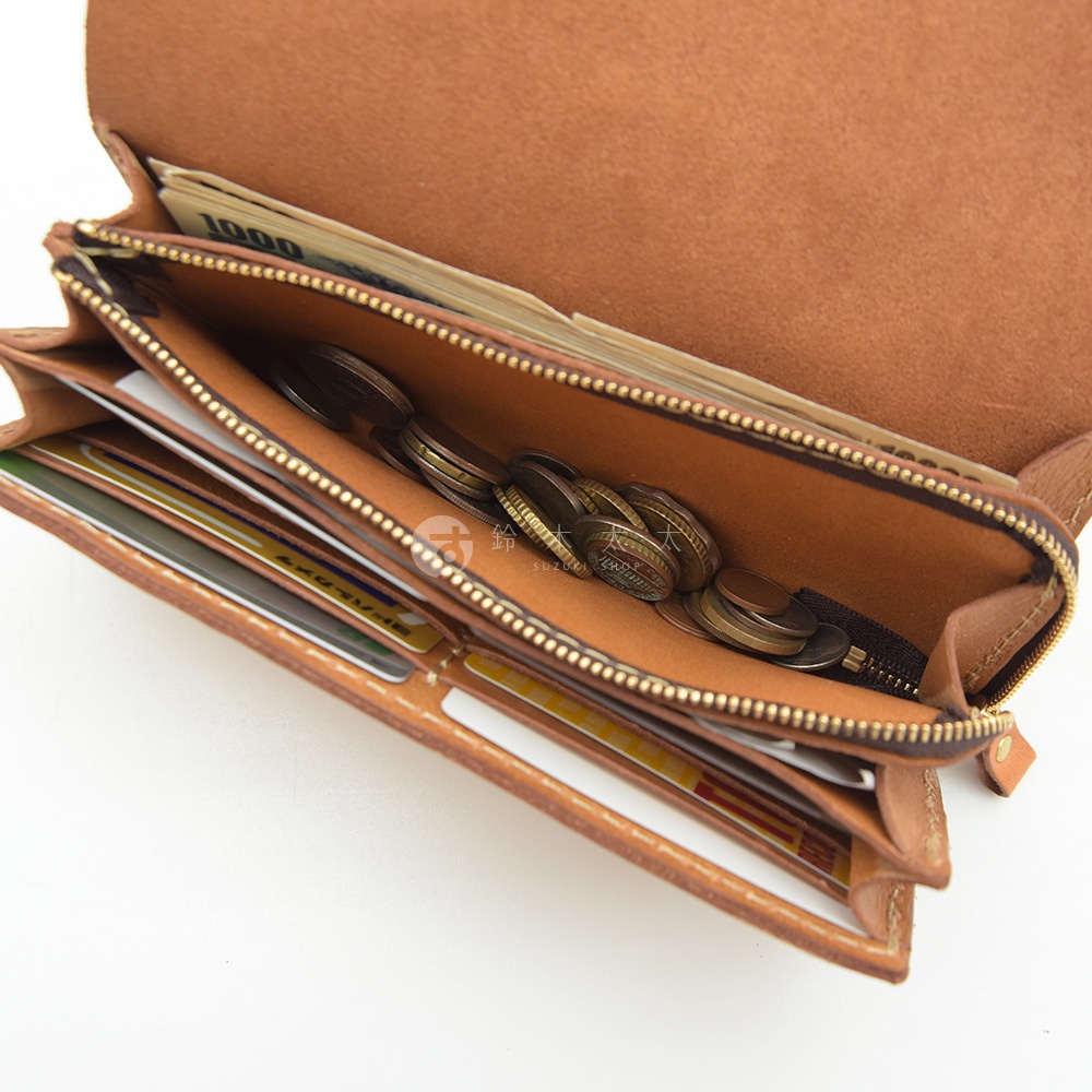 職人手作皮革長夾，展示多卡層設計，內含鈔票、硬幣和多張信用卡。淺棕色皮革材質，搭配金色拉鍊。
