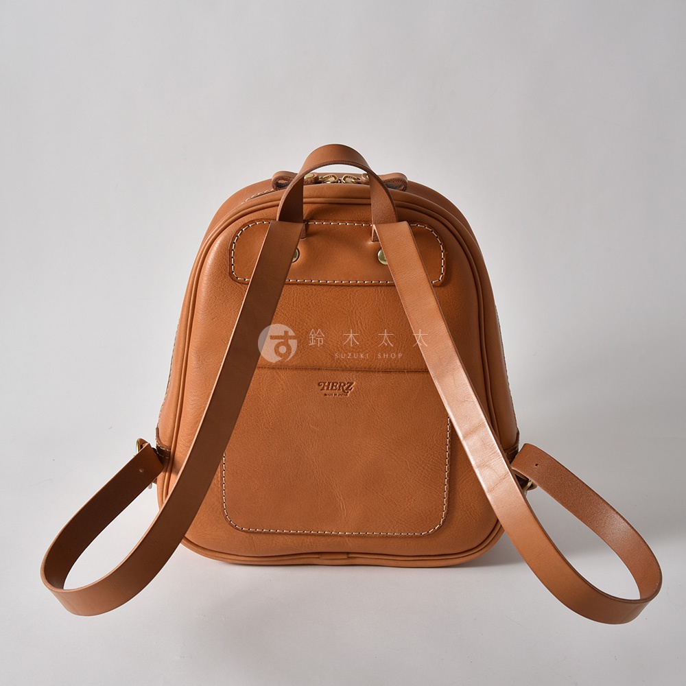 棕色皮革迷你後背包，配有立體前袋和白色縫線，雙肩帶可調節。