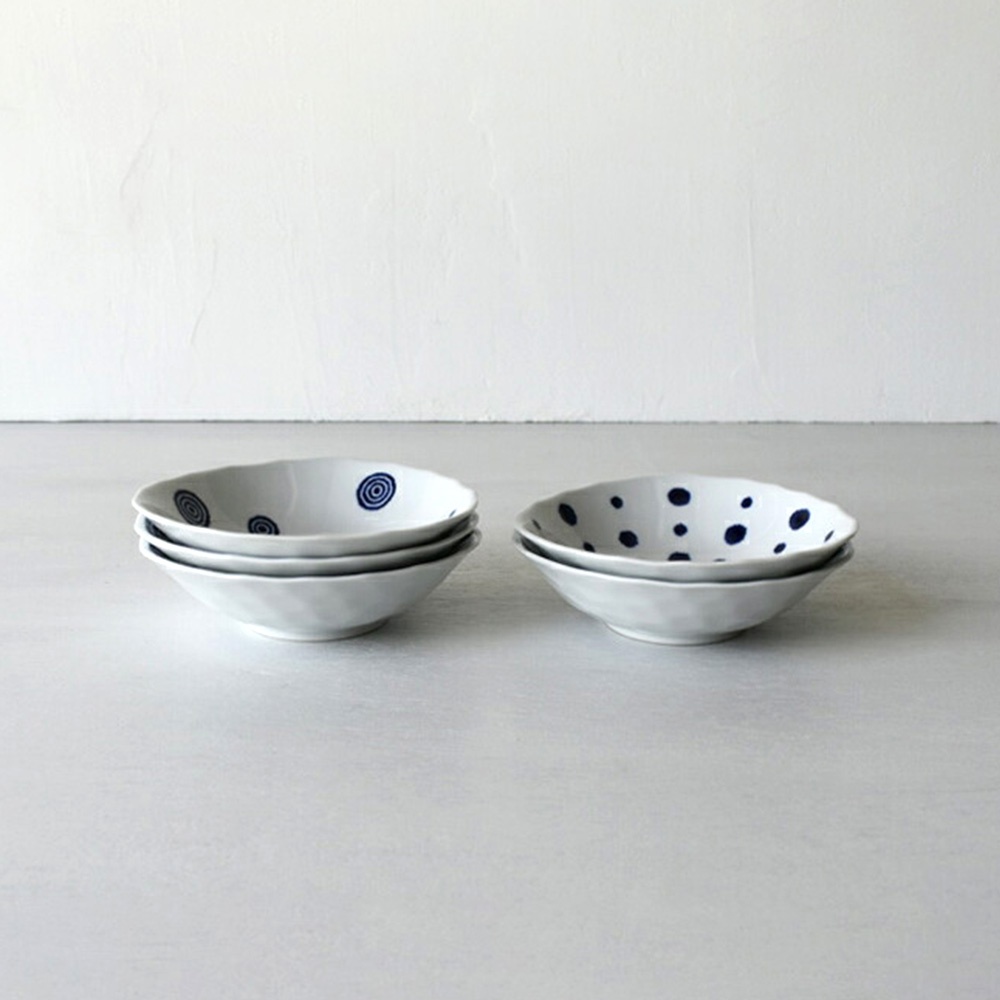 白色陶瓷深盤，表面飾有藍色渦紋或圓點圖案。左側堆疊著三個渦紋盤，右側堆疊著兩個圓點盤。