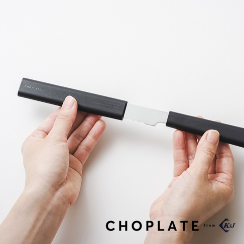 一雙手正將一把銀色金屬刀刃從黑色刀鞘中抽出，刀刃邊緣帶有鋸齒。