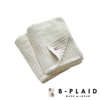 淡米白色 RIB 今治長毛柔暖速乾直紋毛巾，材質柔軟，表面有清晰的直紋織造，一角帶有紅色與藍色組成的品牌標誌。