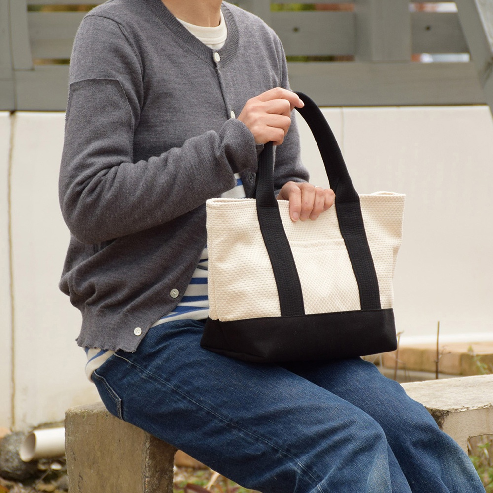 三河木綿刺子織迷你托特包，採用米白色刺子織布料搭配黑色包底和提把，整體設計簡潔實用。