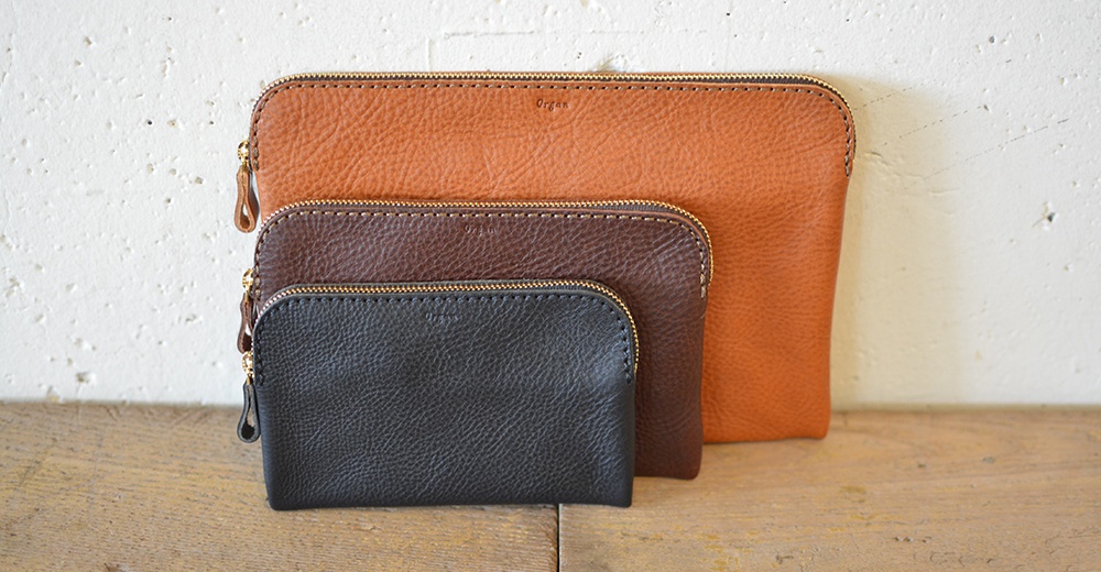 職人手作皮革Organ雙拉鍊收納袋，展示三種尺寸，顏色包含棕色、深棕色與黑色。袋身材質為皮革，帶有細緻的紋理，並配有金色拉鍊及拉鍊頭。