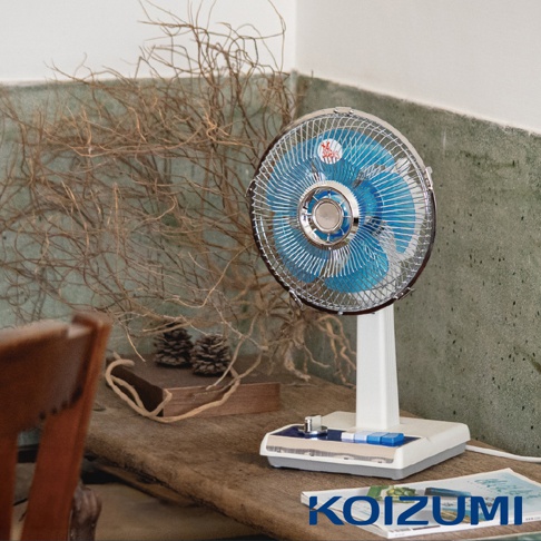 復古風格的白色電風扇，配有藍色扇葉和銀色金屬網罩，底座設計簡潔，上方有銀色旋鈕和藍色按鈕。
