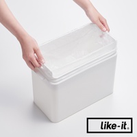 一只手正在為白色長方形垃圾桶內套上透明塑膠垃圾袋，垃圾桶外觀簡潔，側面有提把設計。